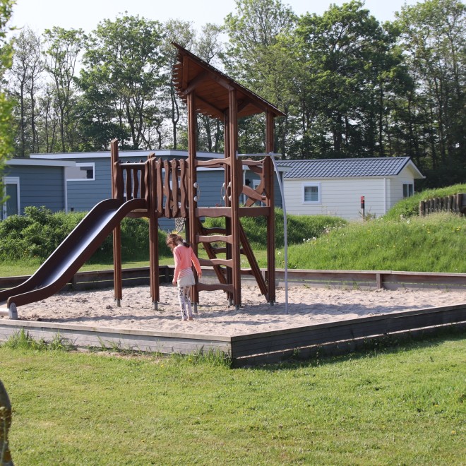 Speeltoestel met glijbaan bij de chalets