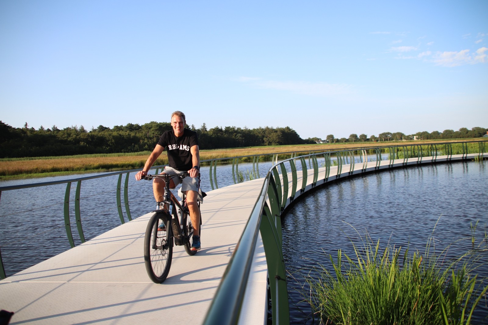 Fietser op een vlonderpad langs het water