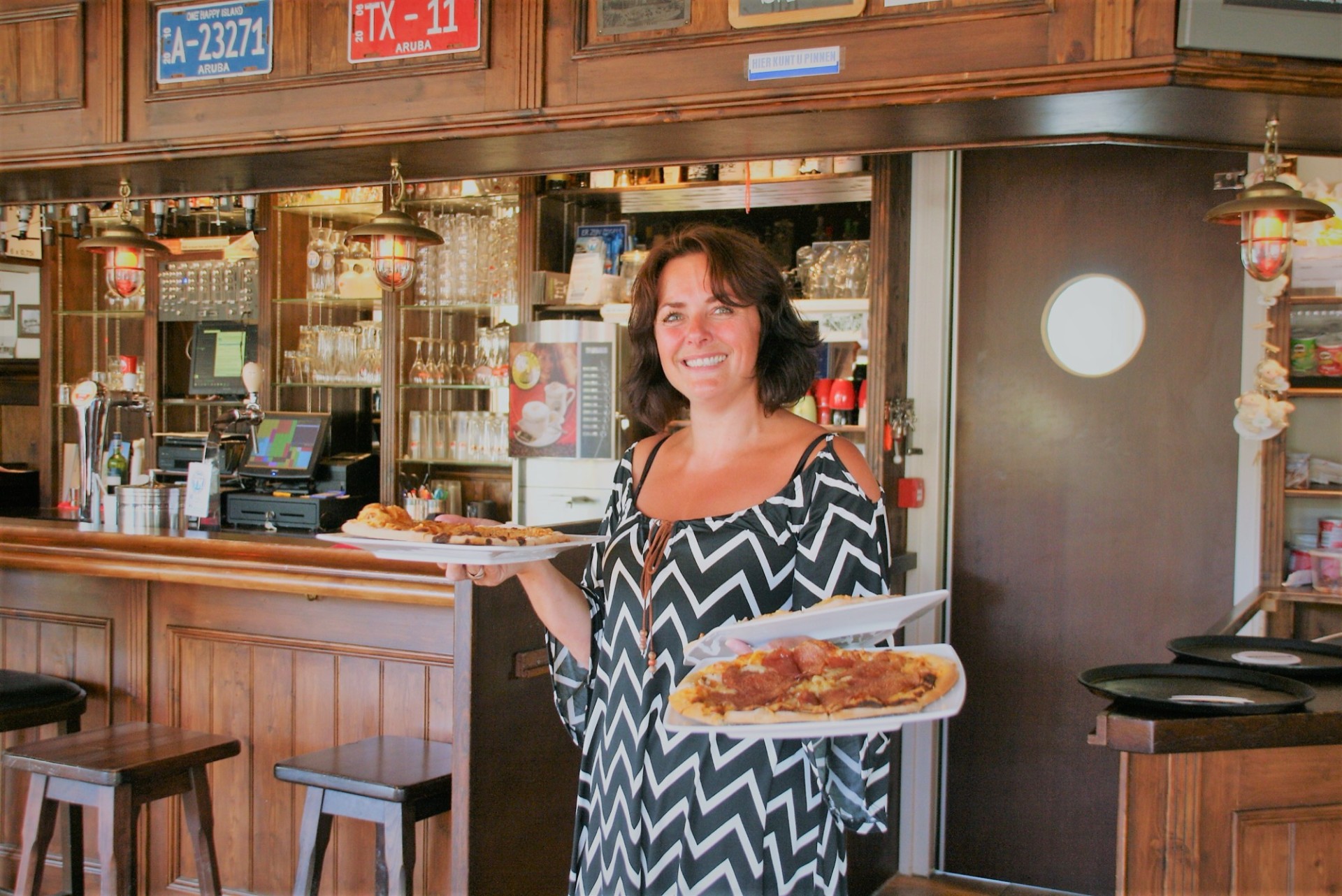 Medewerker van het eetcafé met verse pizza's