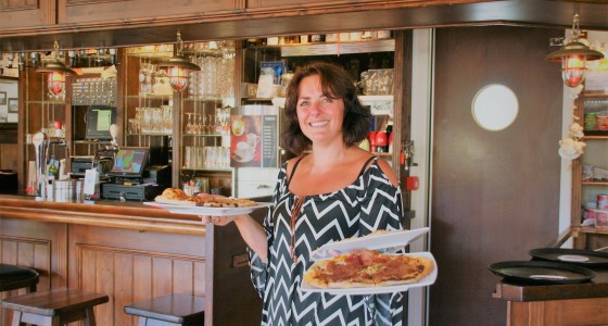 Medewerker van het eetcafé met verse pizza's